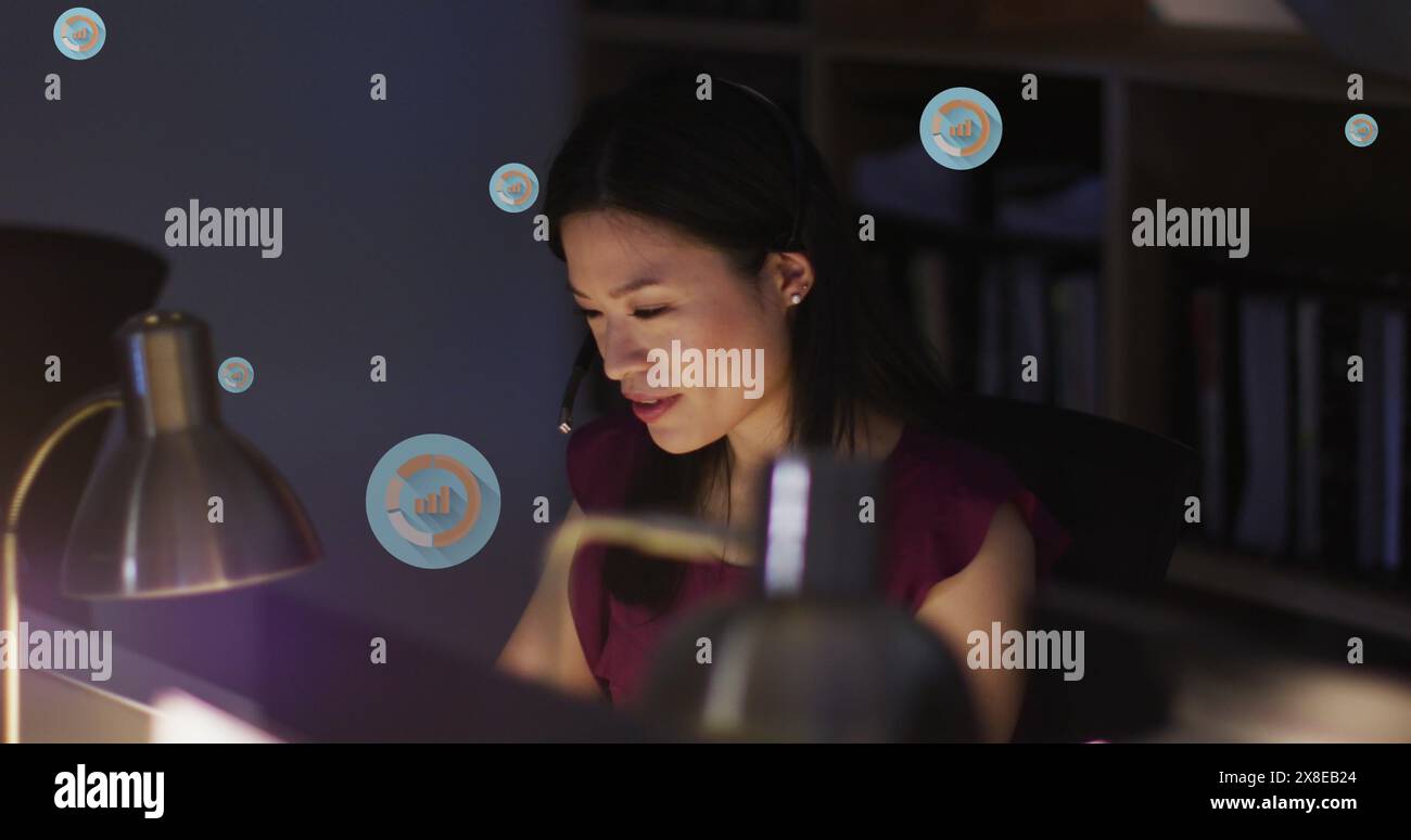 Giovane professionista asiatico che indossa camicetta viola si sta concentrando sullo schermo del suo computer Foto Stock