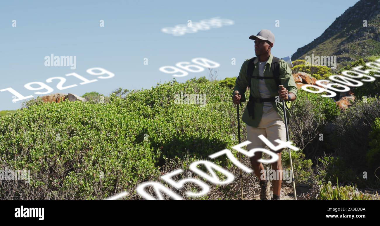 Allenatore birazziale maschile che indossa un cappello, escursionismo su terreni montuosi Foto Stock