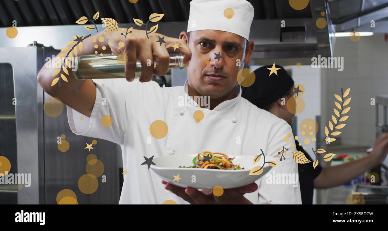 Chef caucasico di mezza età che presenta un piatto di pasta, lavorando in una cucina affollata Foto Stock