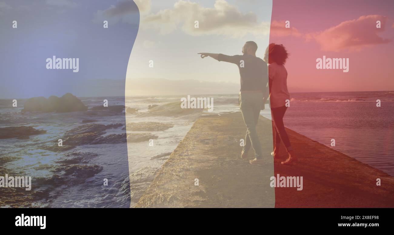 Immagine della bandiera della francia sulla coppia birazziale che cammina in spiaggia Foto Stock