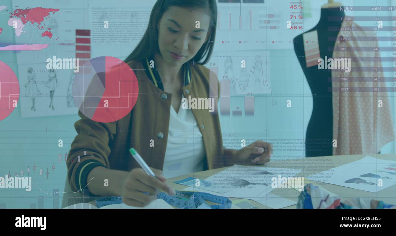 Immagine dell'elaborazione di dati statistici contro la stilista birazziale che lavora in studio Foto Stock