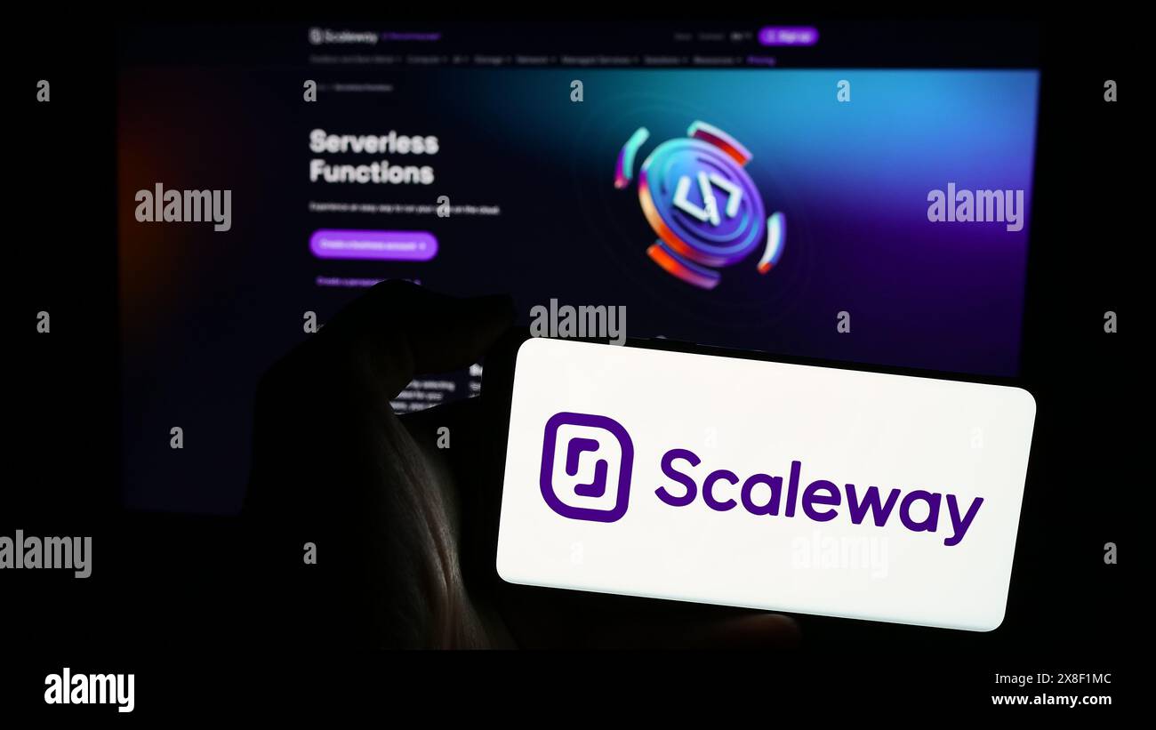 Persona che detiene un telefono cellulare con il logo dell'azienda francese di cloud computing Scaleway SAS davanti alla pagina Web aziendale. Mettere a fuoco il display del telefono. Foto Stock