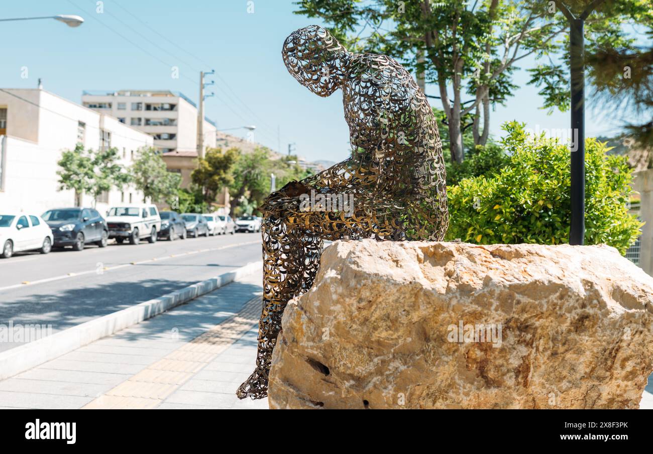 Scultura in metallo di un uomo che legge un libro, fatta di lettere calligrafiche, Shiraz, Iran. Foto Stock