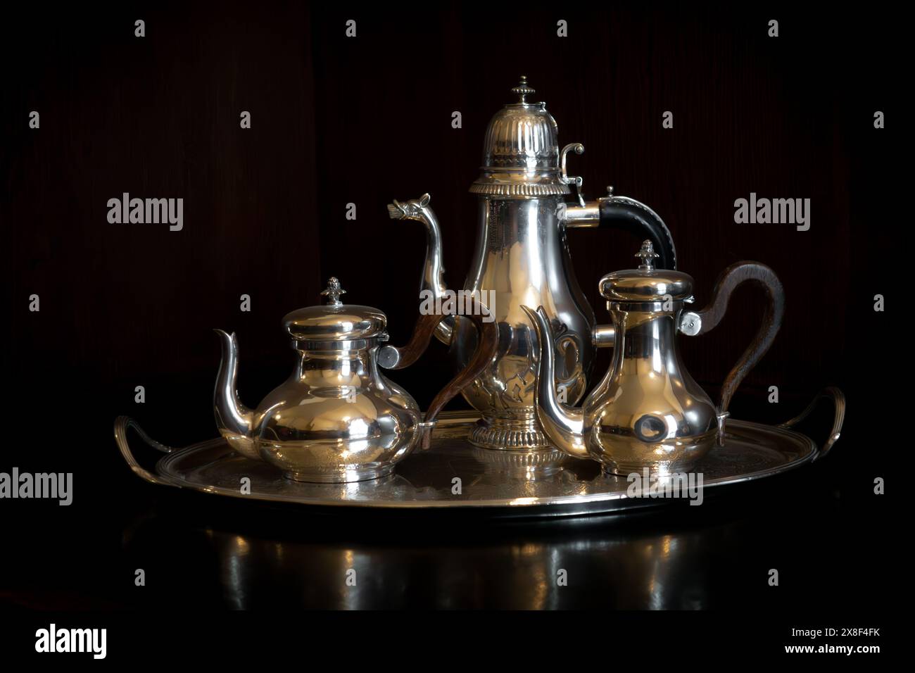 Antico caffè in argento lucido con sfondo in legno nero scuro per l'aristocrazia e il vecchio concetto di ricco denaro a Villa Necchi Campiglio, Mila Foto Stock