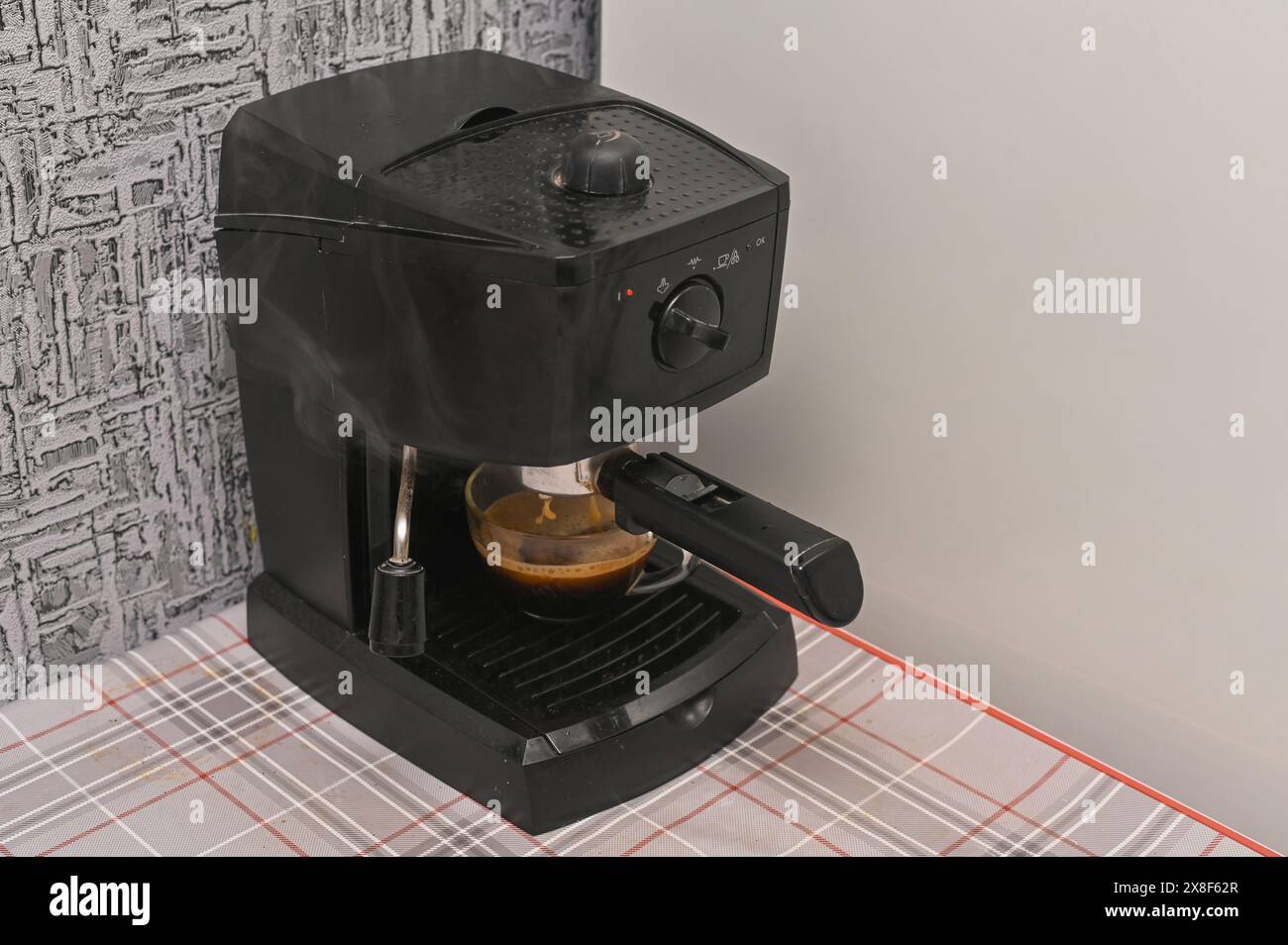 Una macchina per il caffè riempie una tazza di caffè profumato Foto Stock