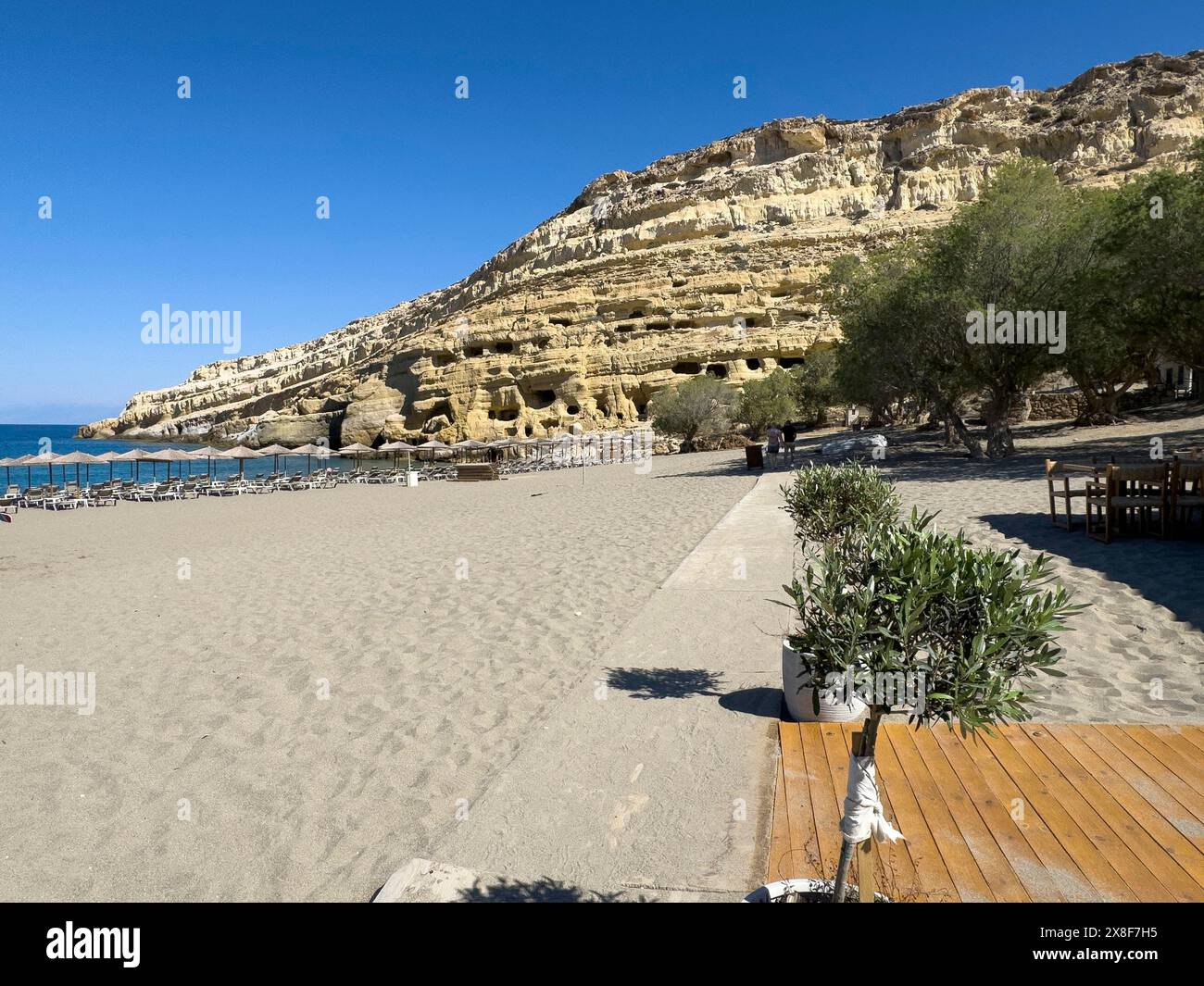 Vista della spiaggia di Matala, sullo sfondo rocce di arenaria con ex necropoli romana con grotte di arenaria scolpite in arenaria grotta tombe Grotte Foto Stock