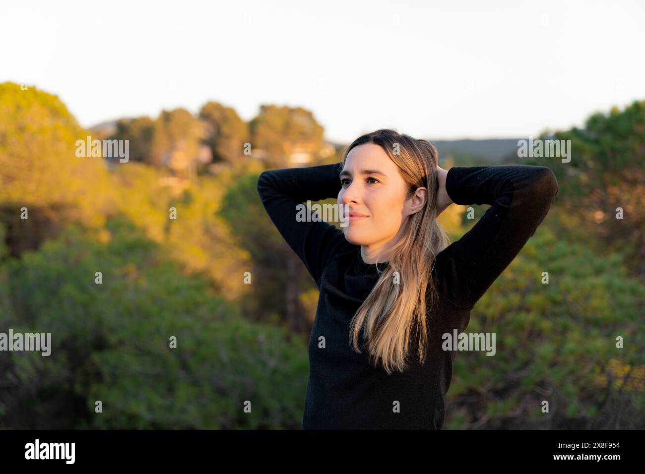 Donna che sorride a contatto con la natura. Pace interiore e benessere emotivo Foto Stock