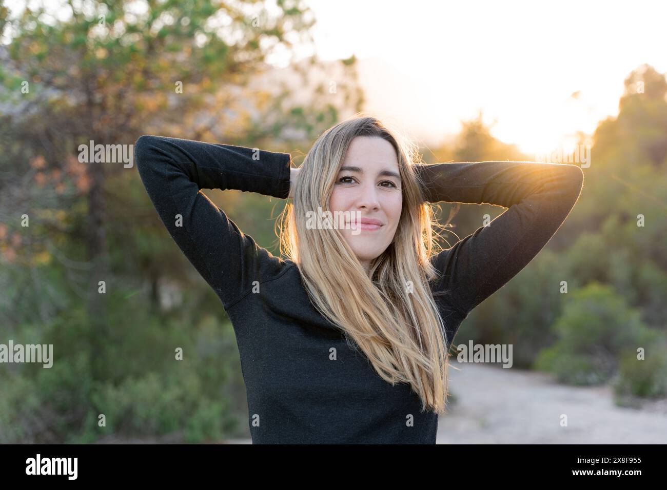 Donna che sorride a contatto con la natura. Pace interiore e benessere emotivo Foto Stock