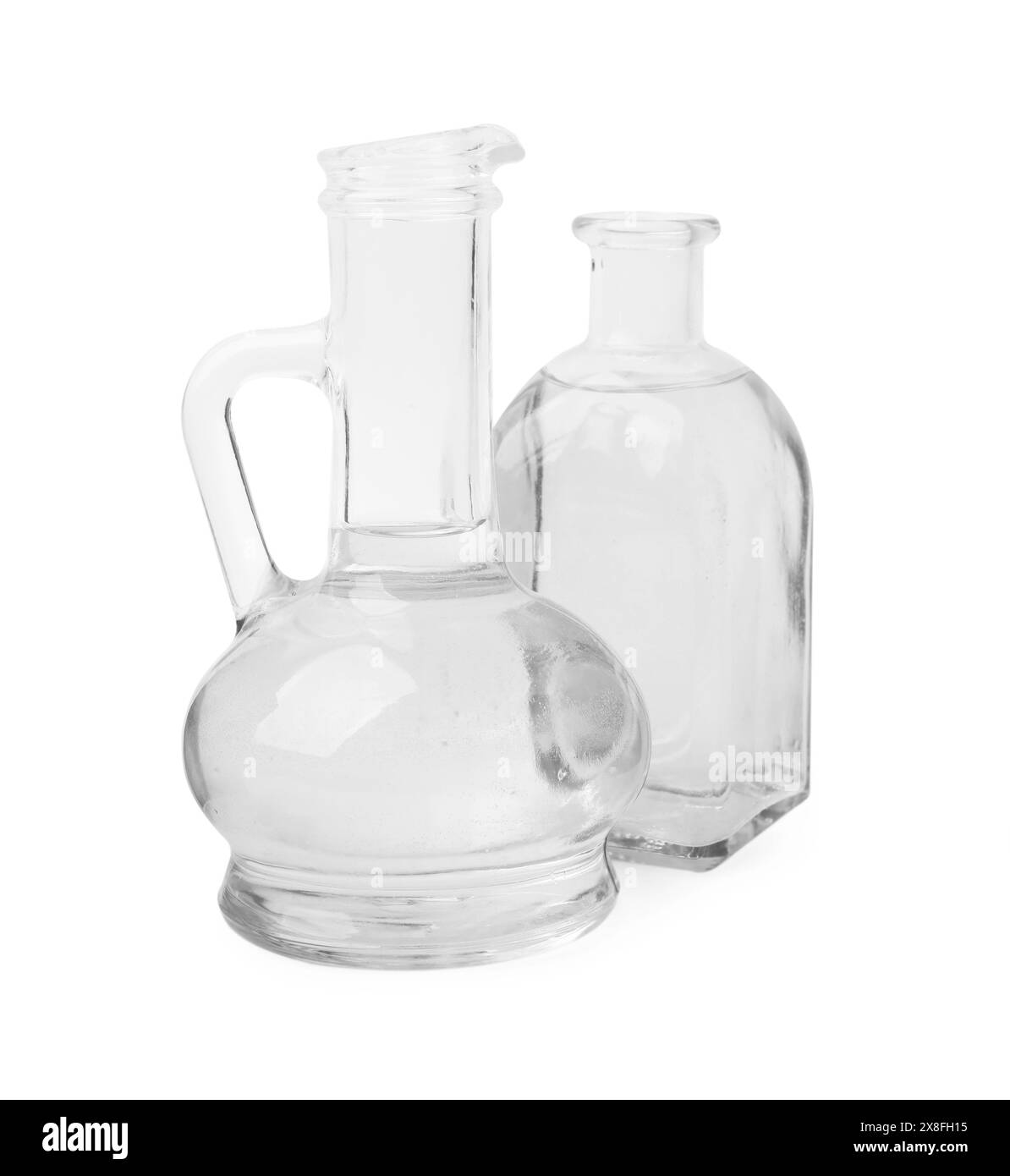 Aceto in una caraffa di vetro e flacone isolato su bianco Foto Stock