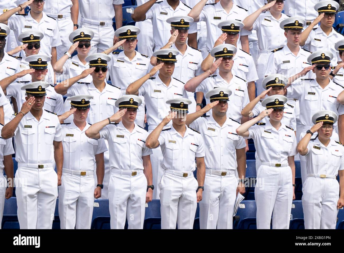 Annapolis, Stati Uniti. 24 maggio 2024. U. I Midshipmen della S Naval Academy salutano durante la riproduzione dell'inno nazionale per la cerimonia di laurea e messa in servizio al Navy-Marine Corps Memorial Stadium, 24 maggio 2024, ad Annapolis, Maryland. U. Il segretario alla difesa Lloyd J. Austin III consegnò il discorso di inizio ai 1.040 guardiamarina della classe del 2024. Credito: PO1 Alexander Kubitza/U.S. Navy/Alamy Live News Foto Stock