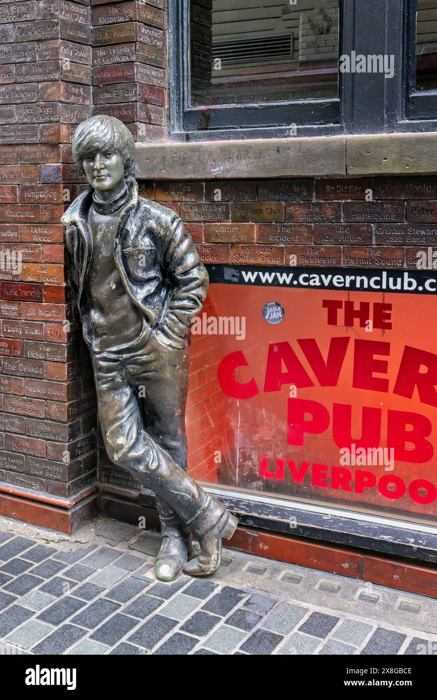 Statua in bronzo di John Lennon appoggiata contro il muro fuori dal Cavern Bar in Matthew Street, Liverpool, Merseyside, Regno Unito il 20 maggio 2024 Foto Stock