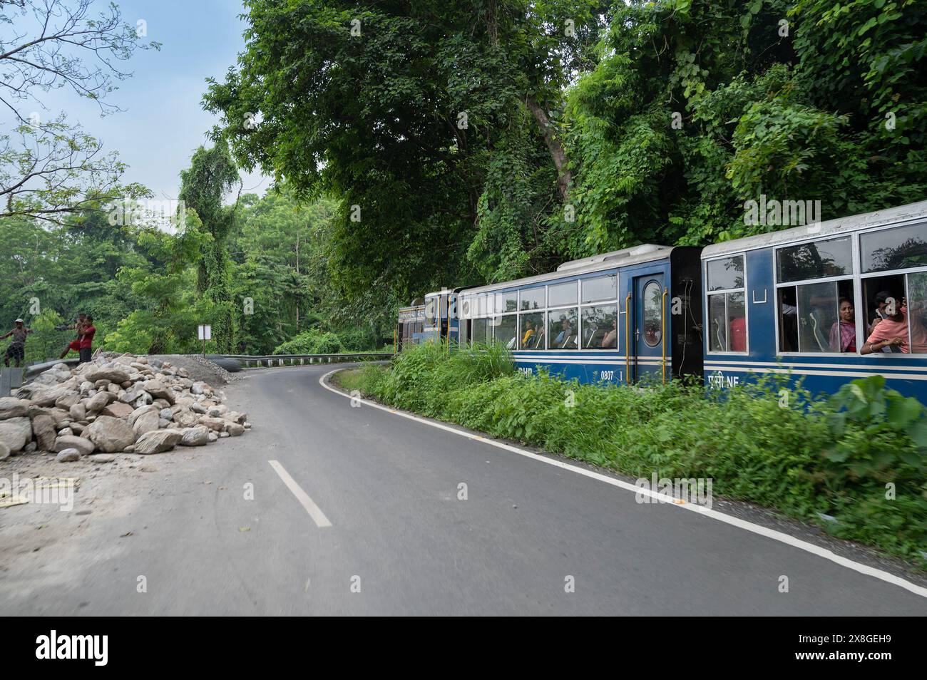 Darjeeling, Bengala Occidentale, India - 10 agosto 2023: La strada himalayana è stata costruita dai lavoratori, mentre il treno Diesel Toy passa attraverso la giungla accanto. Foto Stock