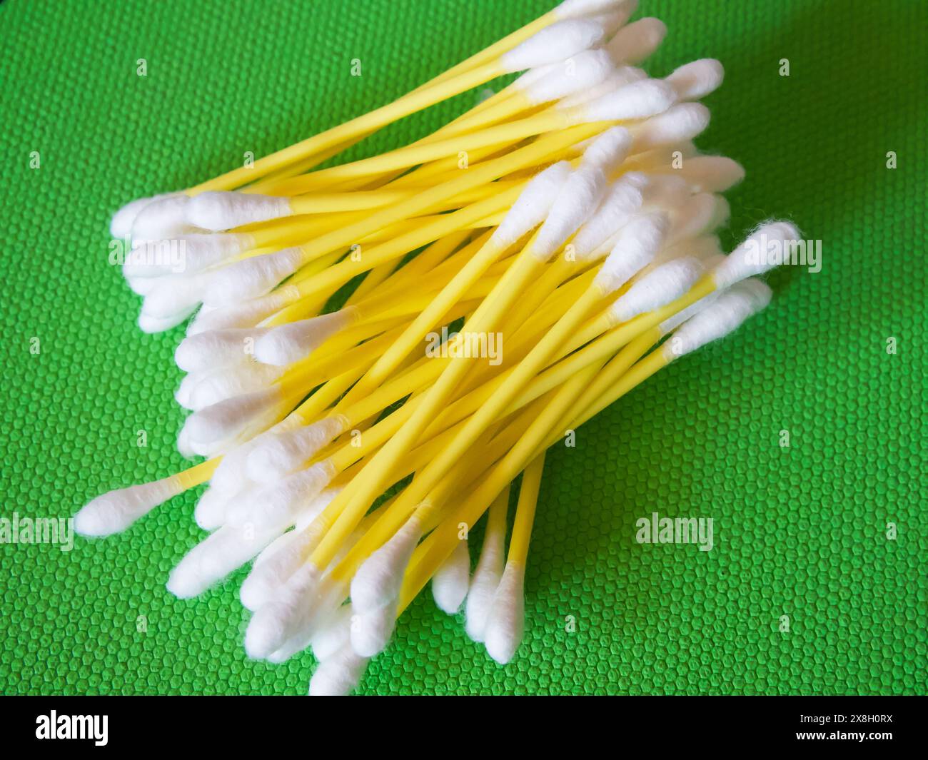 Cura personale. Bastoncini di cotone per l'igiene, disposti su verde. Foto Stock