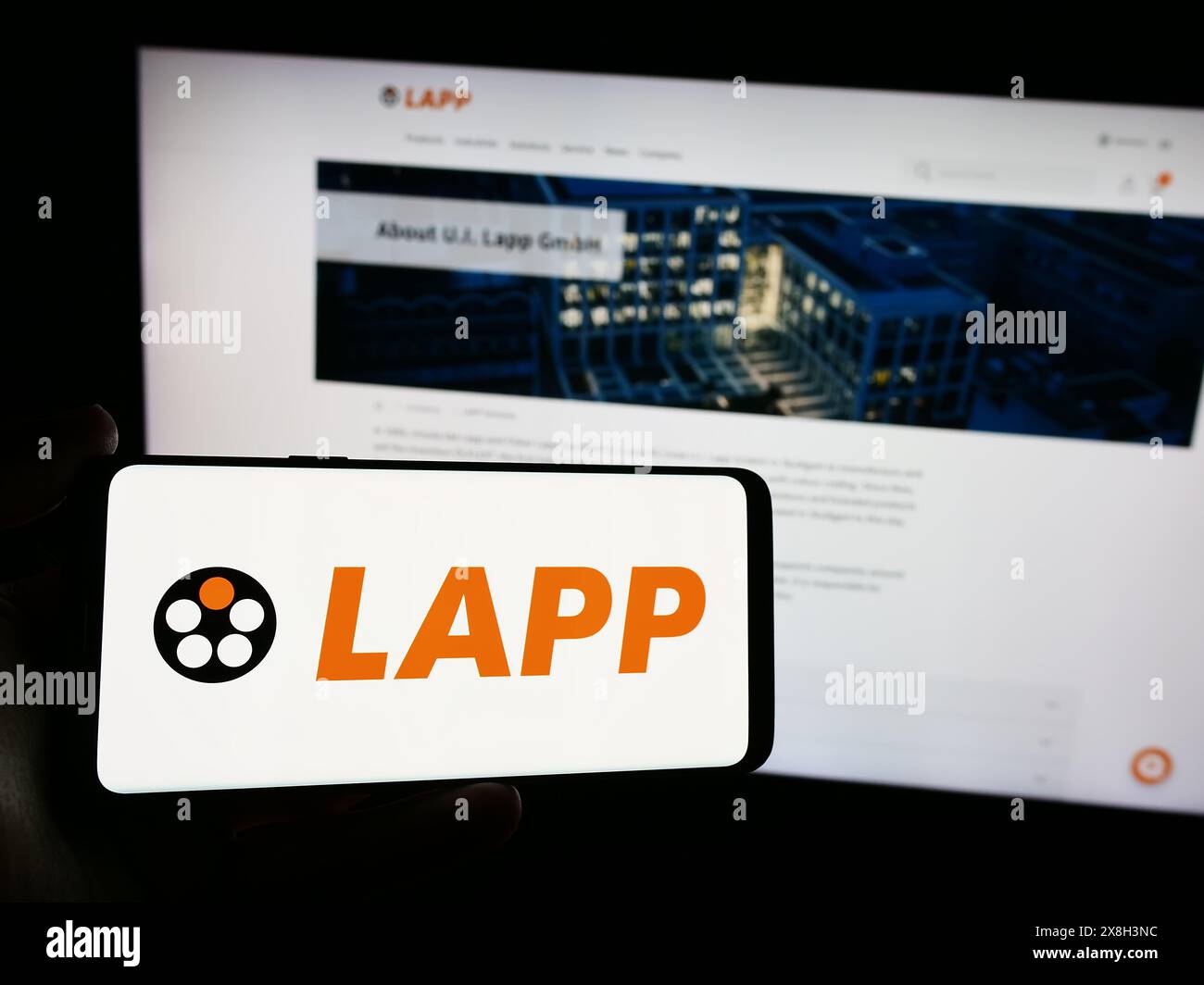 Persona che possiede uno smartphone con il logo della società tedesca via cavo Lapp Holding se davanti al sito web. Mettere a fuoco il display del telefono. Foto Stock
