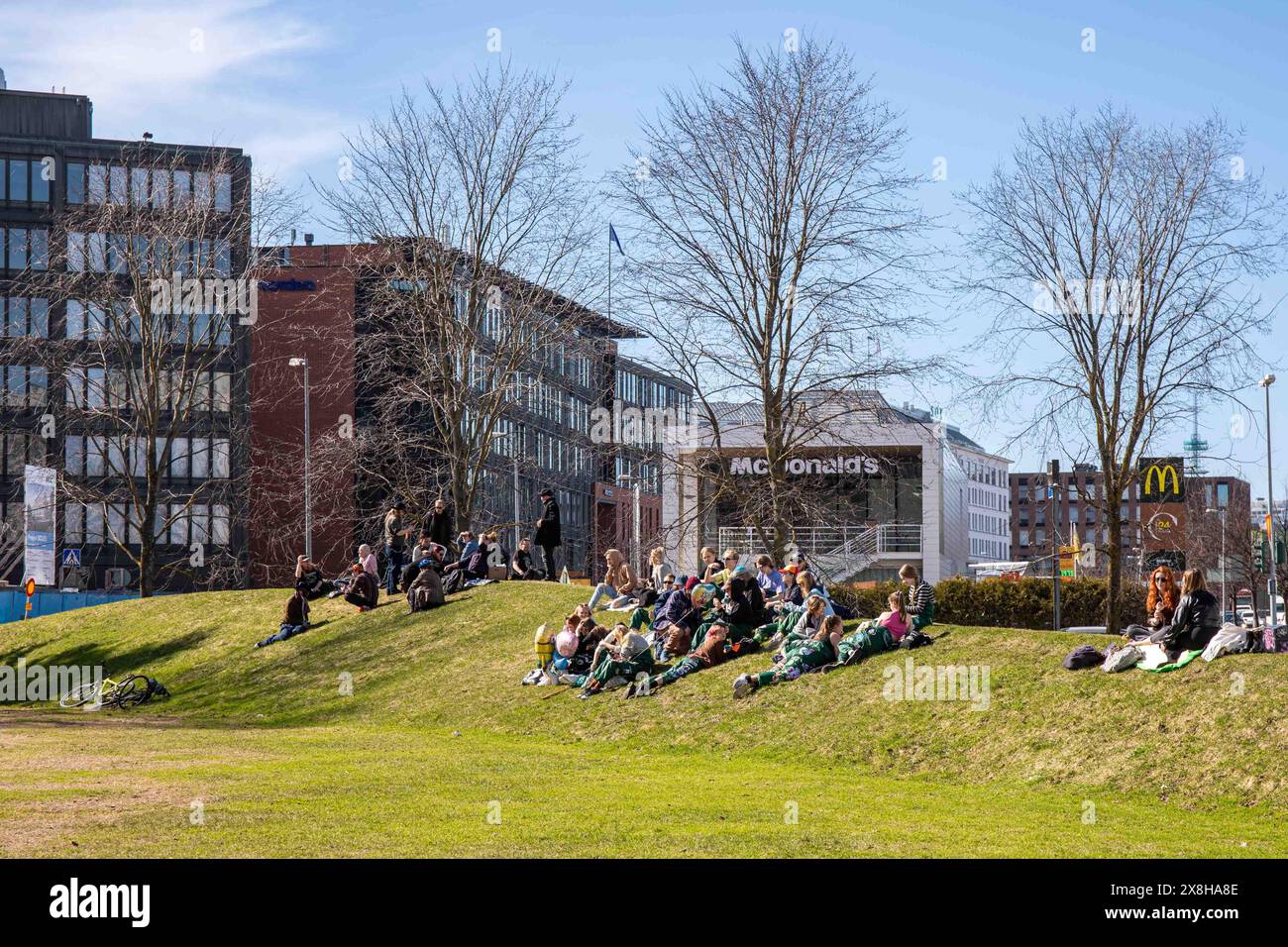 I giovani si godono la calda vigilia di maggio nel Parco Dallapé nel quartiere Vallila di Helsinki, Finlandia Foto Stock