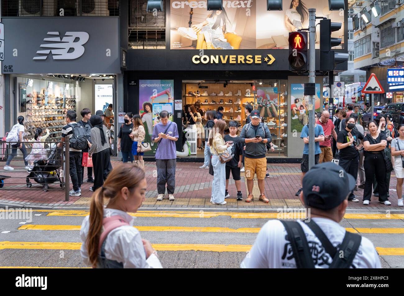 Hong Kong, Cina. 28 aprile 2024. Pedoni e acquirenti sono visti di fronte ai negozi New Balance (NB) e Converse di Hong Kong. (Credit Image: © Sebastian ng/SOPA Images via ZUMA Press Wire) SOLO PER USO EDITORIALE! Non per USO commerciale! Foto Stock