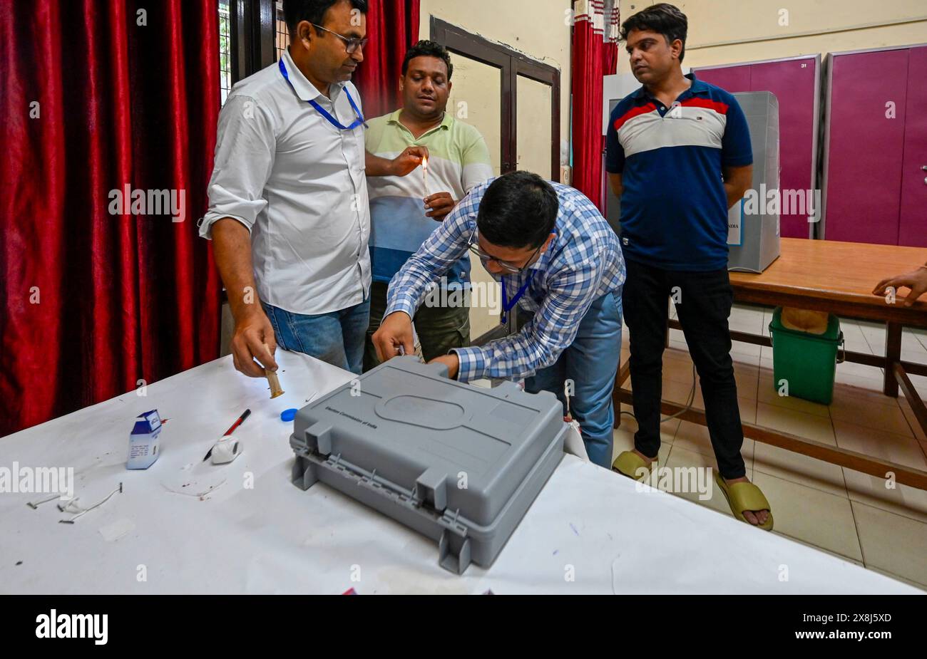 NUOVA DELHI, INDIA - MAGGIO 25: Un funzionario che sigilla le macchine elettorali elettroniche (EVM) dopo la sesta fase di voto per le elezioni del Genral Lok Sabha, a Govt. Ragazzi Senior Secondary School (Bela Road) il 25 maggio 2024 a nuova Delhi, India. Il voto per la sesta fase delle elezioni generali si è concluso in 58 collegi elettorali in sei stati e due territori dell'Unione, compresi tutti e sette i seggi a Delhi. L'affluenza alle urne in sei stati e due territori dell'Unione durante la fase 6 è stata registrata a circa il 58,84%, secondo l'app Voter turnout della commissione elettorale. ( Foto Stock