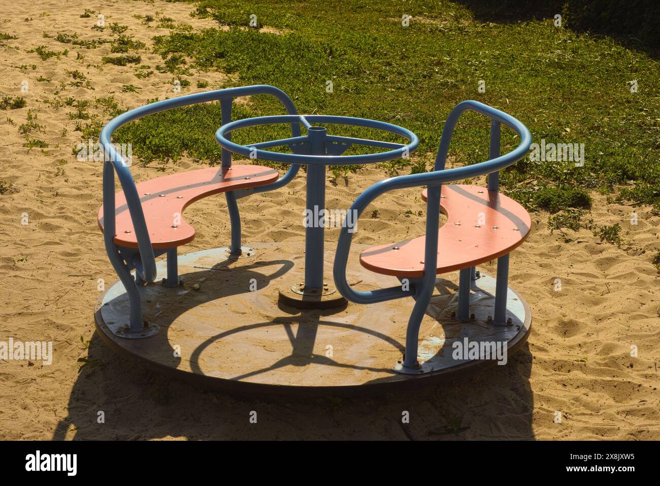 Giostra o giostra in un parco giochi sulla sabbia Foto Stock