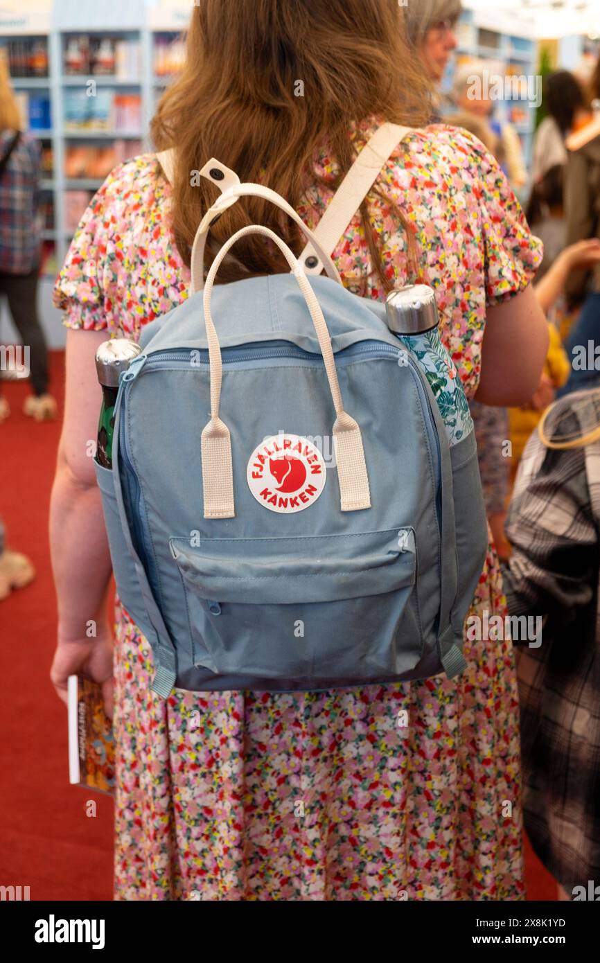 Donna festaiola con vista posteriore dietro dietro la porta con zaino Fjällräven nella fila della libreria Hay Festival 2024 Galles Regno Unito KATHY DEWITT Foto Stock