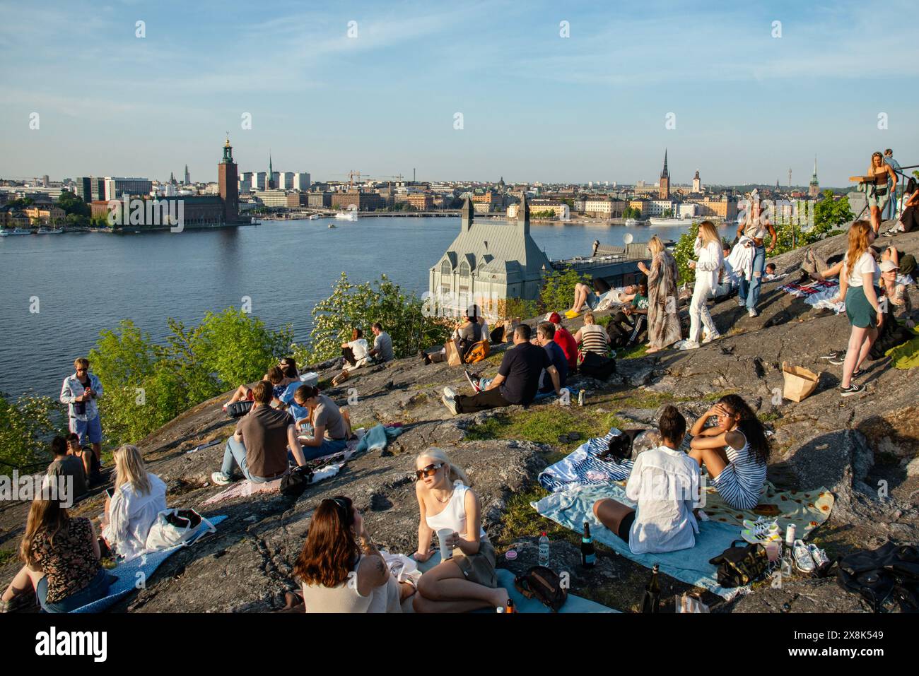 Stoccolma, Svezia - 25 maggio 2024: I giovani riposano a Skinnarviksberget Mountain Party Place durante il tramonto estivo. Luogo popolare. Foto Stock