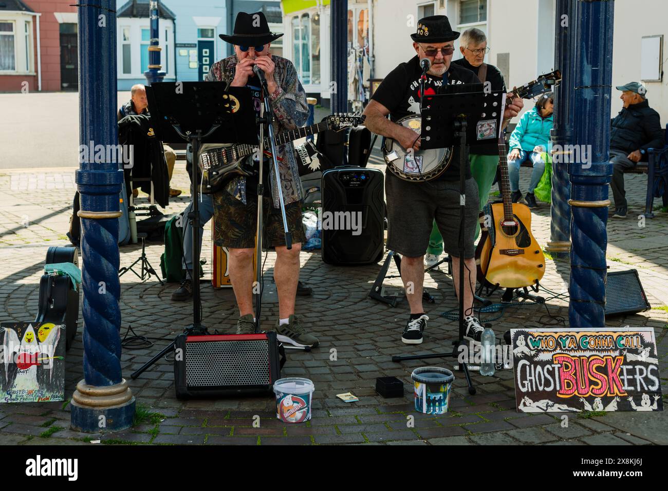 La banda dei pensionati Ghostbuskers cambia in prima linea in armonica e Banjo. Esibizione presso la tribuna di John Street, Porthcawl, Regno Unito. 24 maggio 2024. Foto Stock