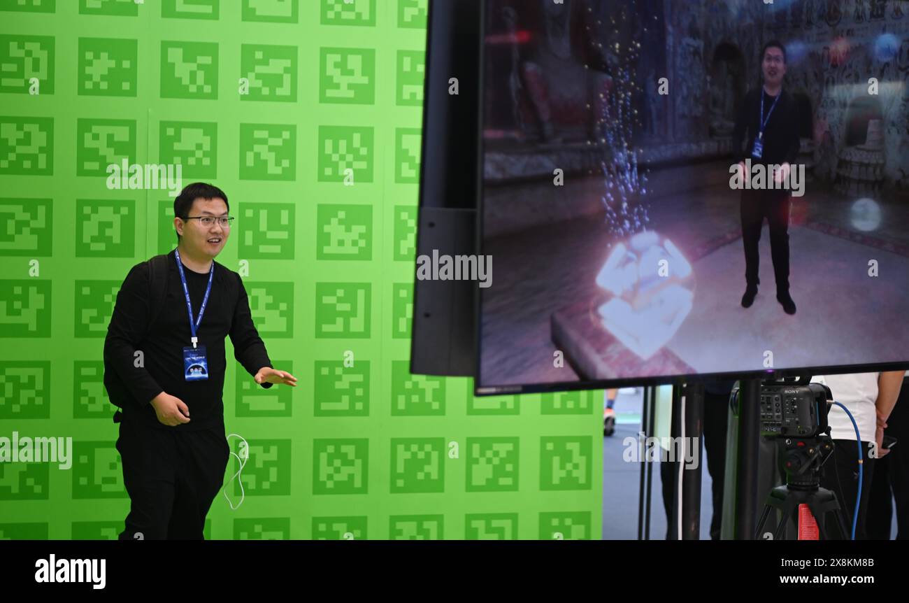 (240526) -- SHENZHEN, 26 maggio 2024 (Xinhua) -- Un visitatore gesta mentre testa la tecnologia di sintesi degli effetti speciali video in tempo reale durante la 20a China (Shenzhen) International Cultural Industries Fair (ICIF) a Shenzhen, nella provincia del Guangdong della Cina meridionale, 23 maggio 2024. La 20a ICIF ha aperto giovedì nella metropoli cinese meridionale di Shenzhen. La fiera presenterà nuove forme di business e nuove applicazioni attraverso la combinazione di contenuti multimediali come ai e AR. (Xinhua/Deng Hua) Foto Stock