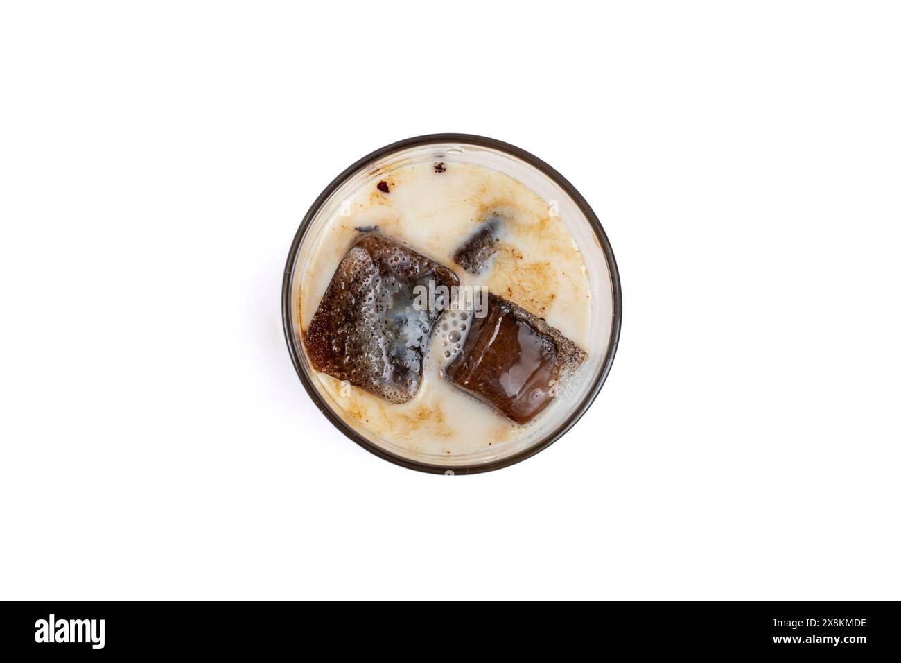 Cubetti di caffè congelati in un bicchiere con latte, isolati su bianco Foto Stock