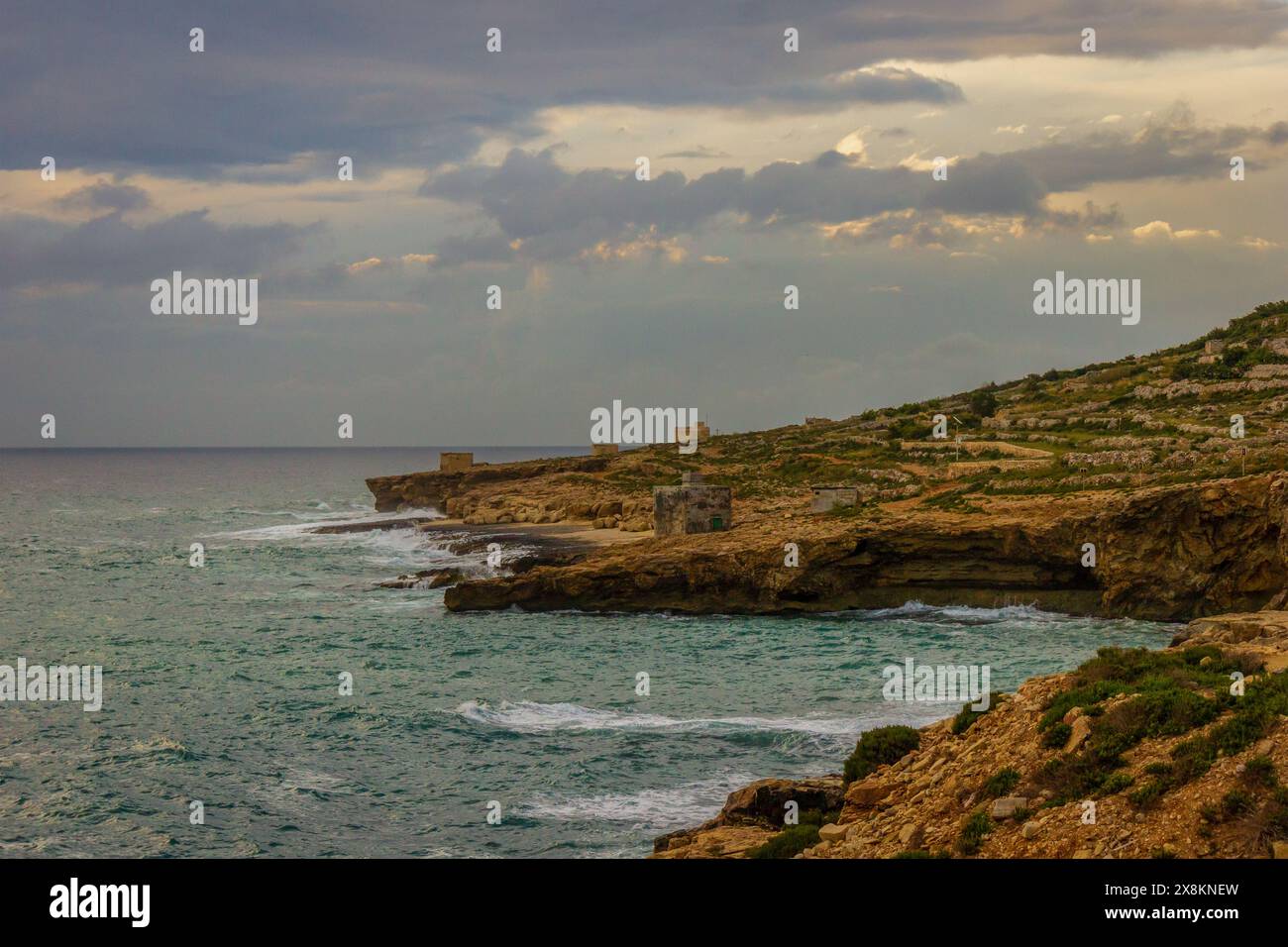 La bellezza della natura è racchiusa in questo meraviglioso paesaggio marino. Un oceano tranquillo incontra la costa rocciosa e un cielo blu incornicia le sue maestose scogliere Foto Stock