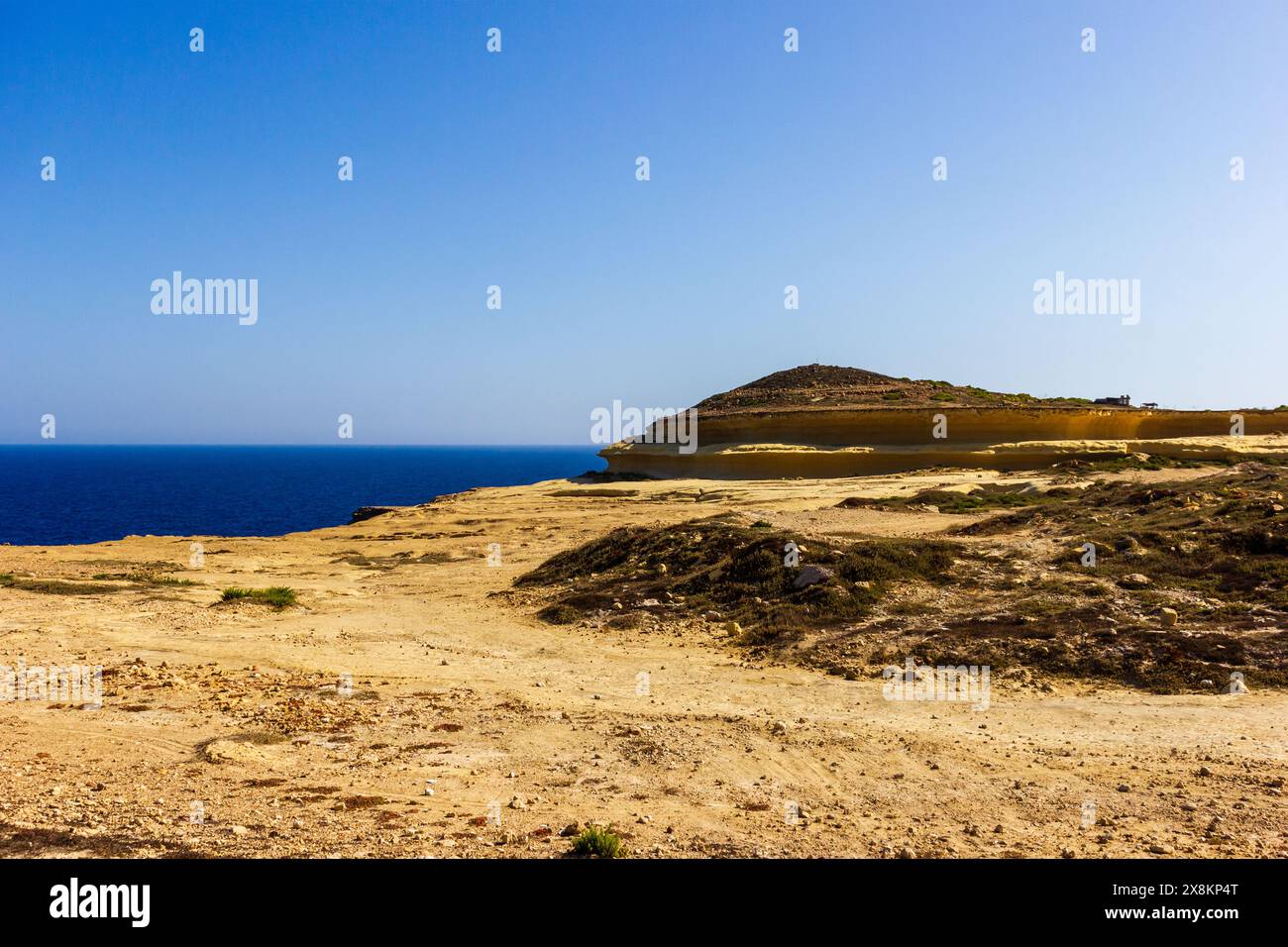 Scogliera che si affaccia sul mare e sul cielo blu, la bellezza serena della natura. Foto Stock