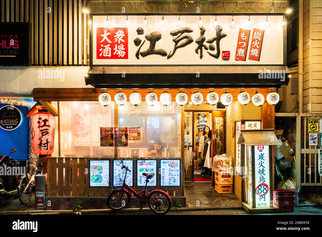 Esterno di un tipico bar giapponese Izakaya, cibo e bevande. Lanterne bianche Chochin, porta aperta e finestre rivestite con carta bianca per una maggiore privacy. Foto Stock