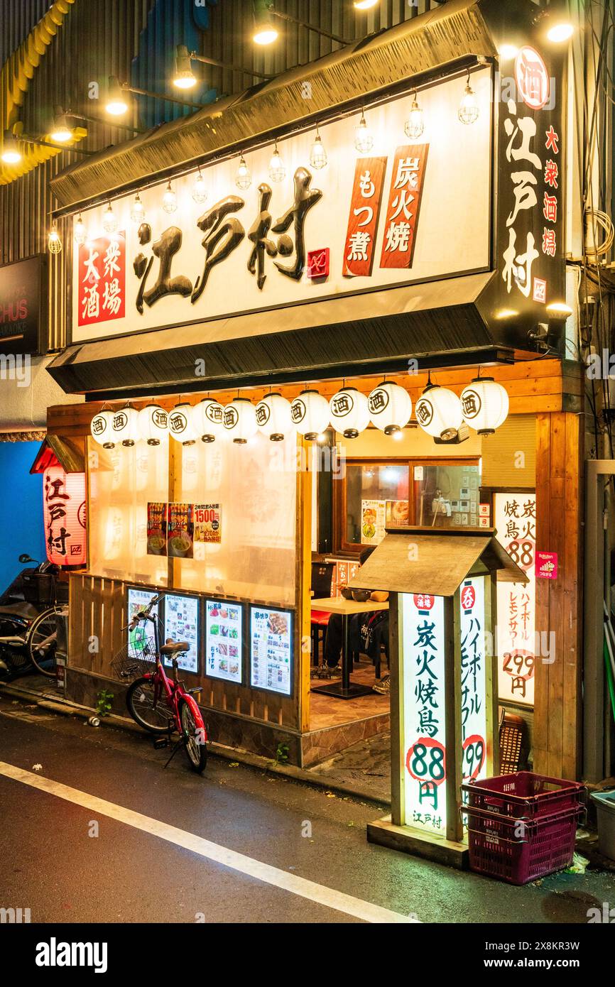 Esterno di un tipico bar giapponese Izakaya, cibo e bevande. Lanterne bianche Chochin, porta aperta e finestre rivestite con carta bianca per una maggiore privacy. Foto Stock
