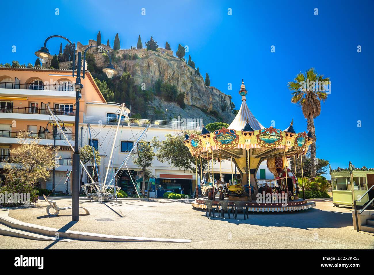 Vista sulla giostra della città di Cassis e sulla fortezza collinare, a sud della Francia Foto Stock