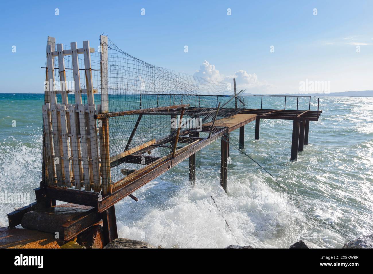 Molo dei pescatori abbandonato, trebuchet su palafitte di ferro a Torre del sale, Piombino, Toscana, Italia Foto Stock