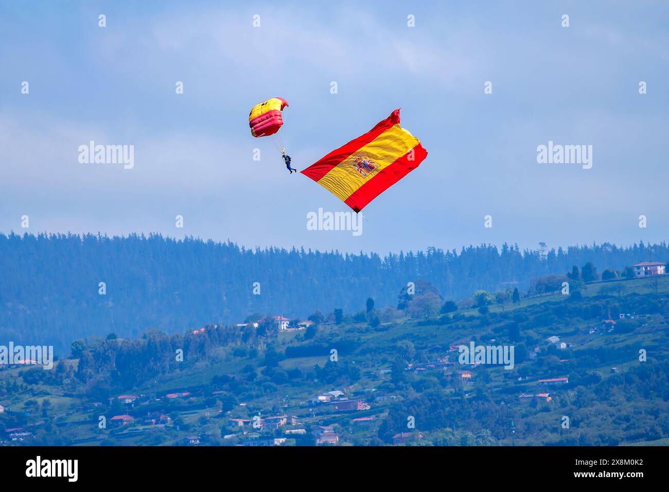 I paracadutisti scendono con la bandiera spagnola in occasione della giornata delle forze armate a Gijon, Asturie. Foto Stock