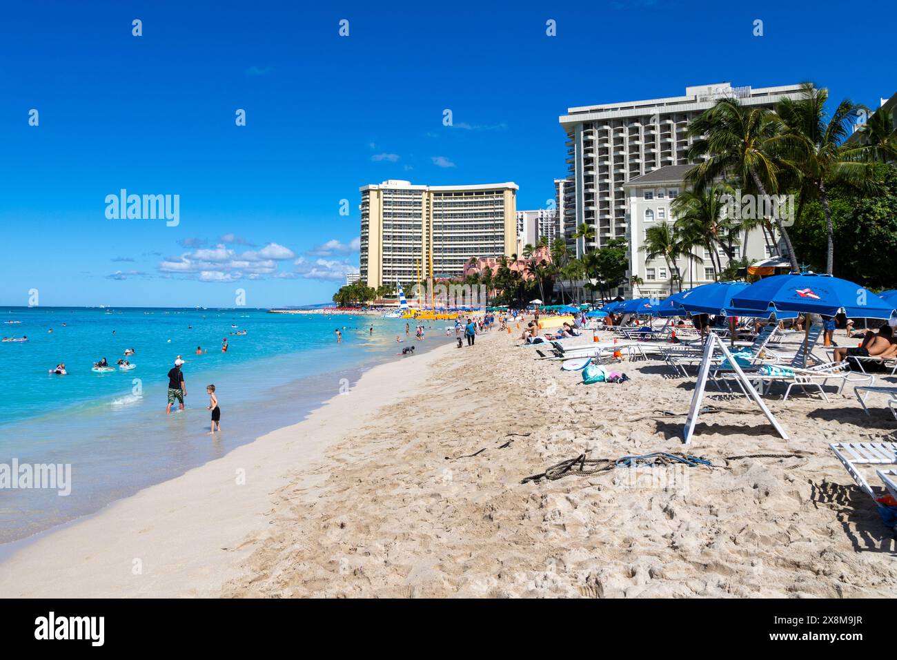 HONOLULU, HAWAII, STATI UNITI - AUG. 20 2023: Affollata spiaggia di Waikiki a Honolulu con turisti che prendono il sole e nuotano nelle isole Hawaii. Foto Stock