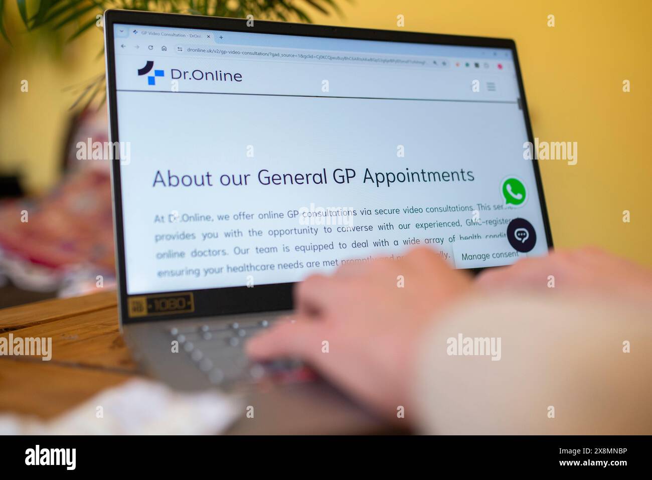 Persona che utilizza un computer portatile per visualizzare un servizio di consultazione online GP, evidenziando l'assistenza sanitaria digitale e gli appuntamenti medici virtuali Foto Stock
