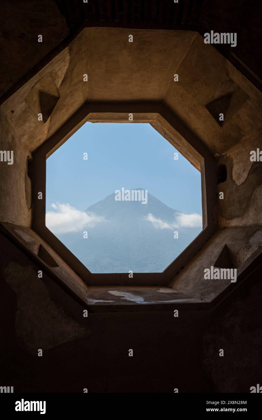 Vista del Vulcano dell'acqua attraverso una finestra ottagonale della Chiesa e del Convento di Santa Clara, Antigua, Guatemala Foto Stock