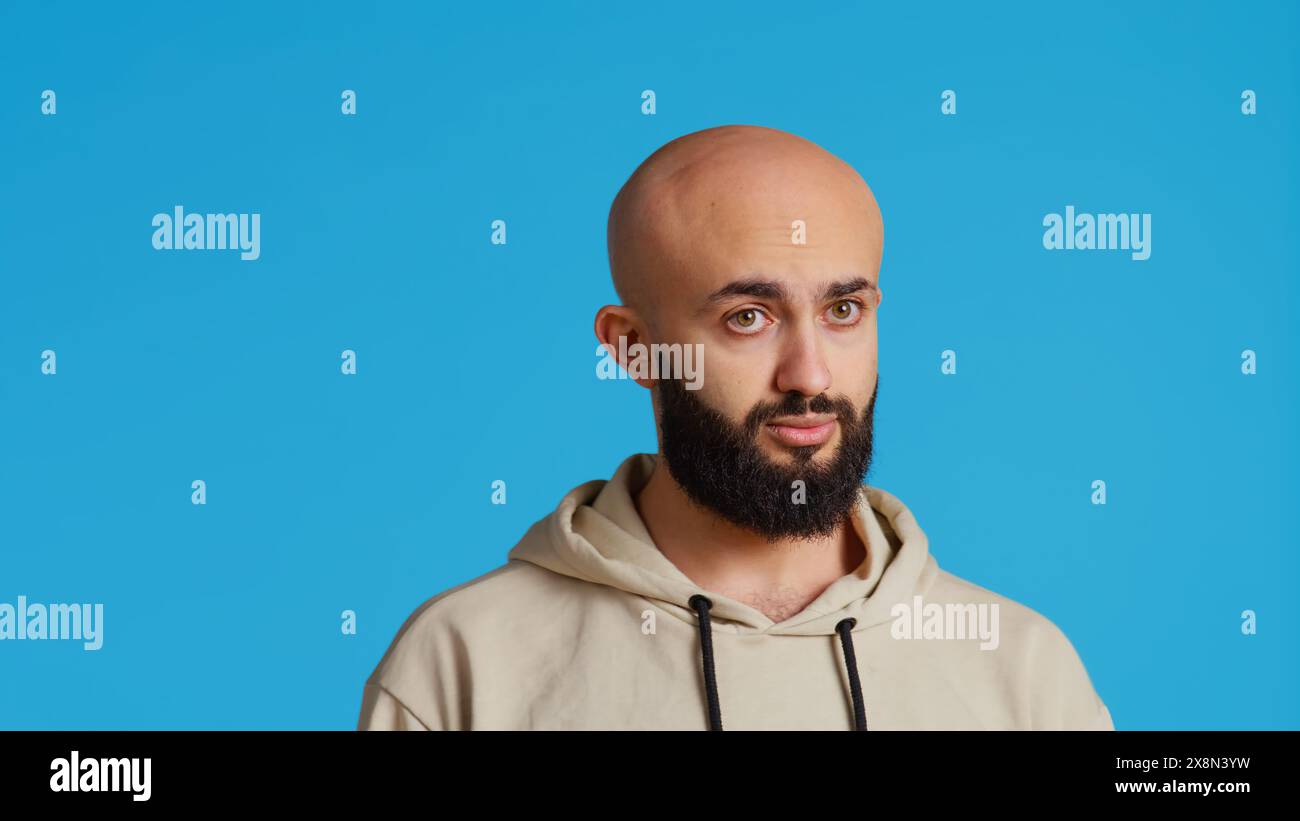Persona araba che mostra un segno negativo con le dita, esprimendo il suo rifiuto davanti alla telecamera. Il ragazzo del Medio Oriente non fa alcun simbolo in studio, presentando un gesto di rifiuto e restrizione. Telecamera 2. Foto Stock