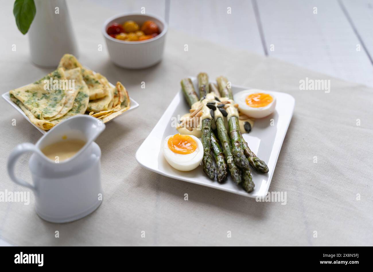 Asparagi verdi serviti con uova sode. Gli asparagi sono molto popolari in Germania durante Spargelzeit, che rappresenta una fonte di fibre alimentari Foto Stock