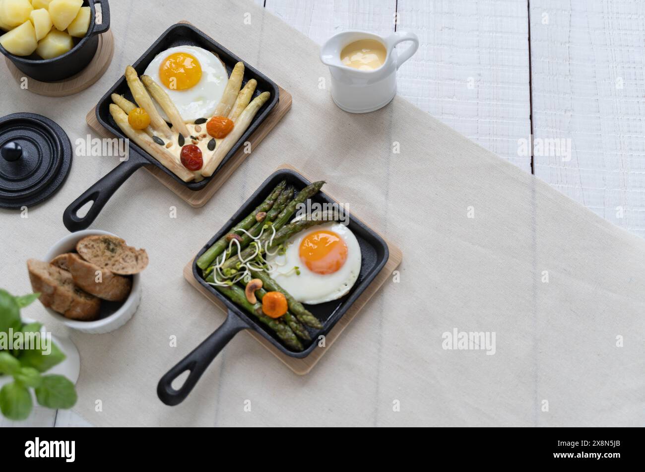 Asparagi verdi e bianchi serviti con pomodori, uova fritte, patate bollite. Questo piatto di stagione è molto popolare in Germania durante lo Spargelzeit Foto Stock