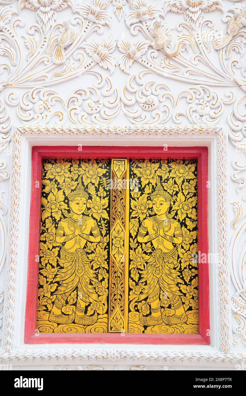 Decorazioni su parete e finestra della biblioteca di scritture a Wat Chang Kham, Wiang Kum Kam Foto Stock