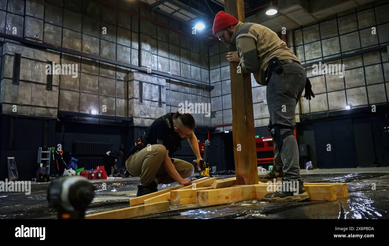 Lavoratori che installano travi in legno per prestazioni ottimali. Supporto. Decorazioni creative. Foto Stock