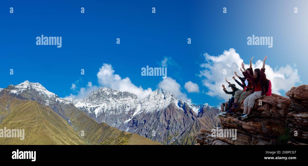 Gruppo di escursionisti felici ha alzato le braccia sulla collina. scalatori di successo Foto Stock