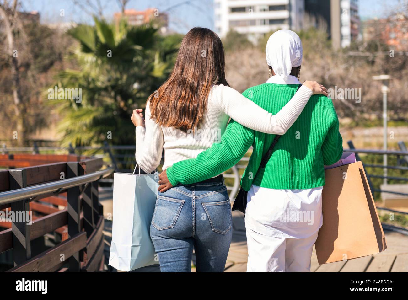 due amici che camminano in un parco con le borse della spesa Foto Stock