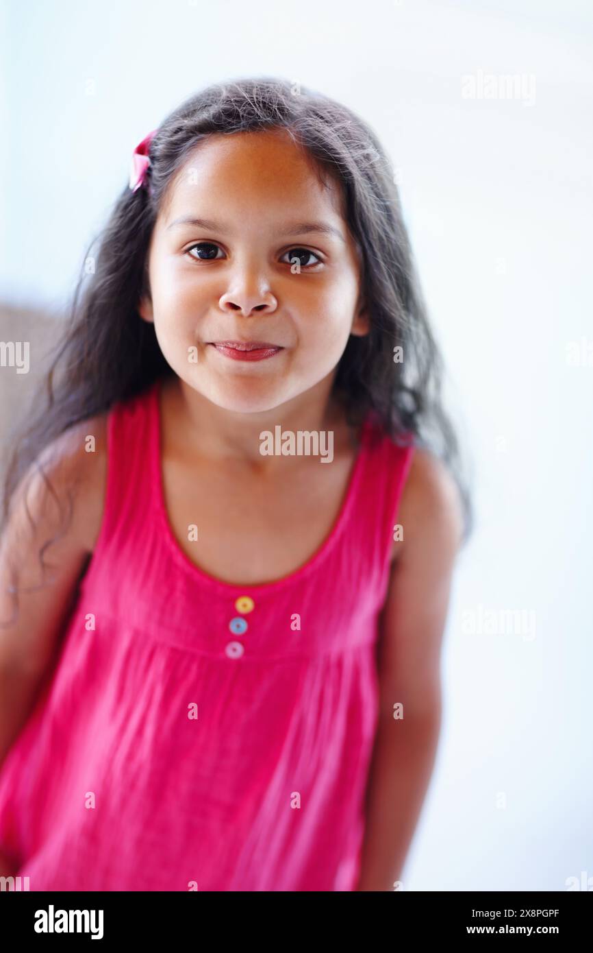 Divertente, faccia e ragazza in ritratto con personalità giocosa per giocare, ridere o giovani felici a scuola. Comico, bambino e espressione facciale in abito per Foto Stock