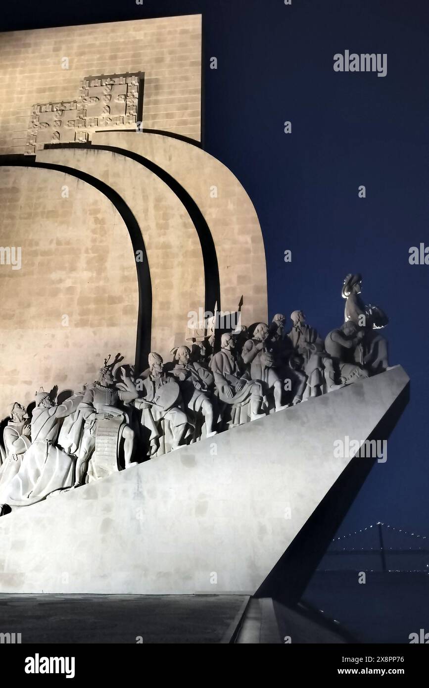 Monumento ai scopritori, sculture e dettagli architettonici, vista laterale illuminata di notte, Belem, Lisbona, Portogallo Foto Stock