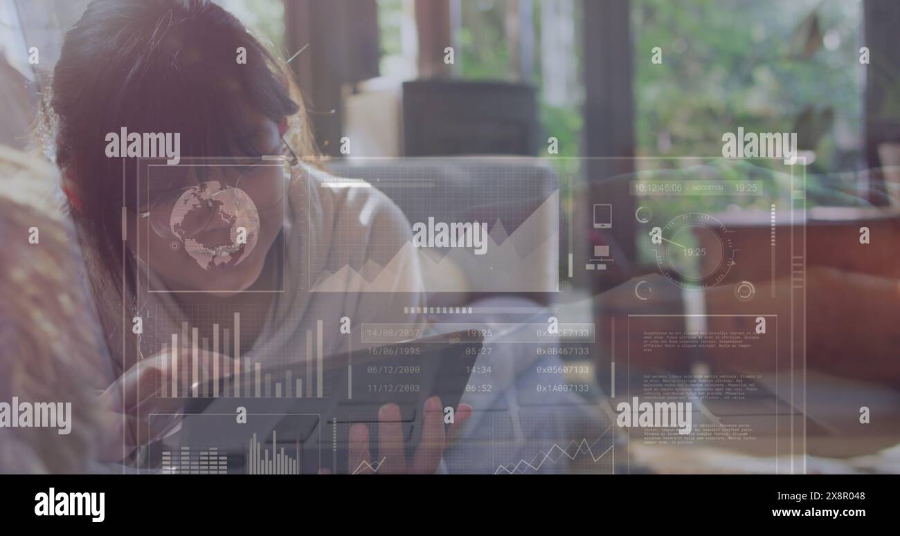 Immagine dell'interfaccia con l'elaborazione dei dati contro la ragazza asiatica che usa il tablet sul divano di casa Foto Stock