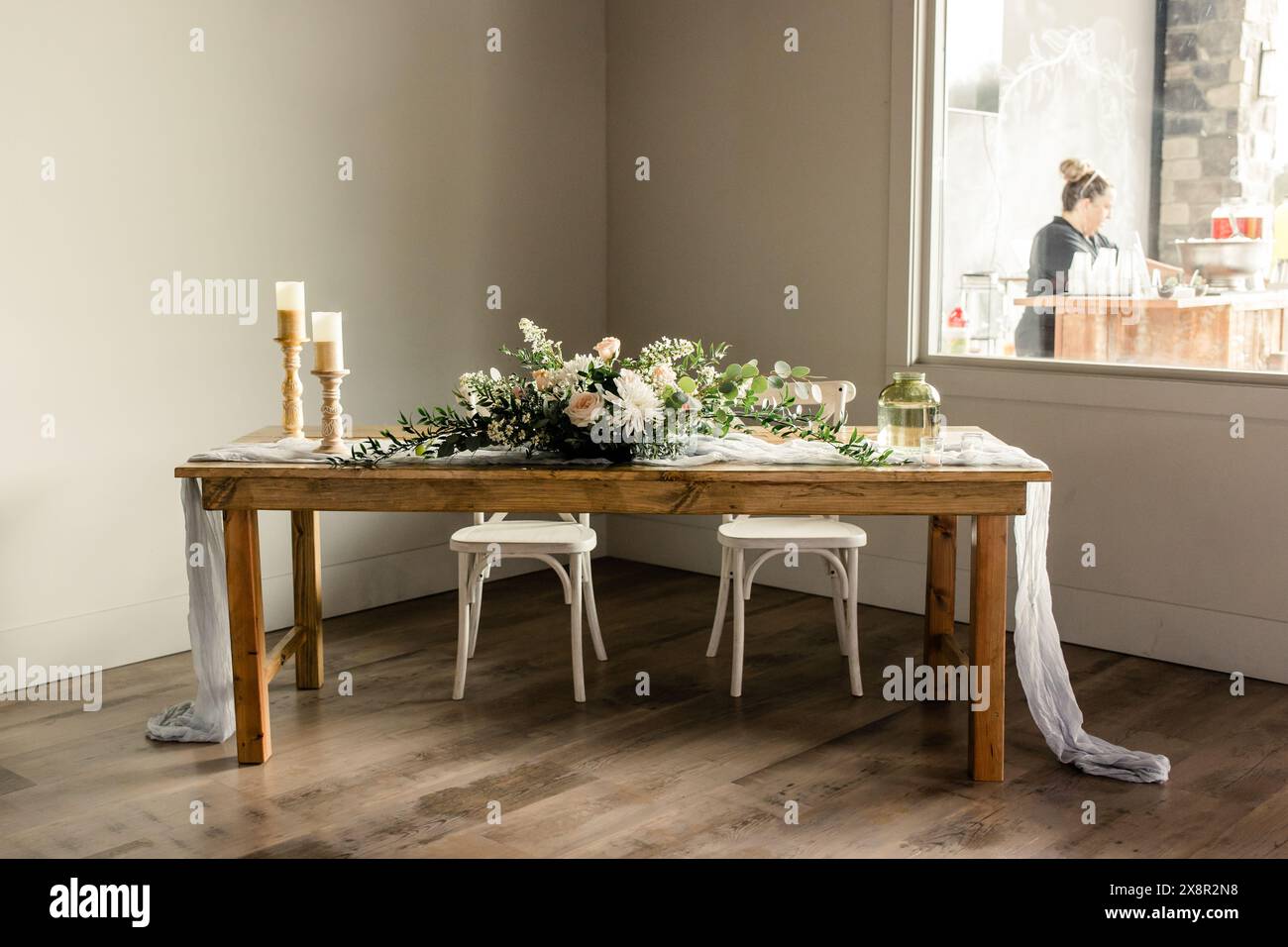 Tavolo in legno con centrotavola floreale e candele Foto Stock