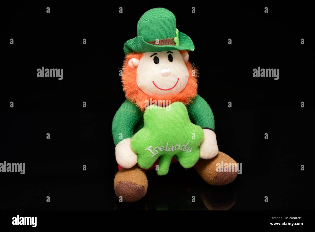 Sorridente giocattolo Leprechaun decorativo di cimeli irlandesi sul nero Foto Stock
