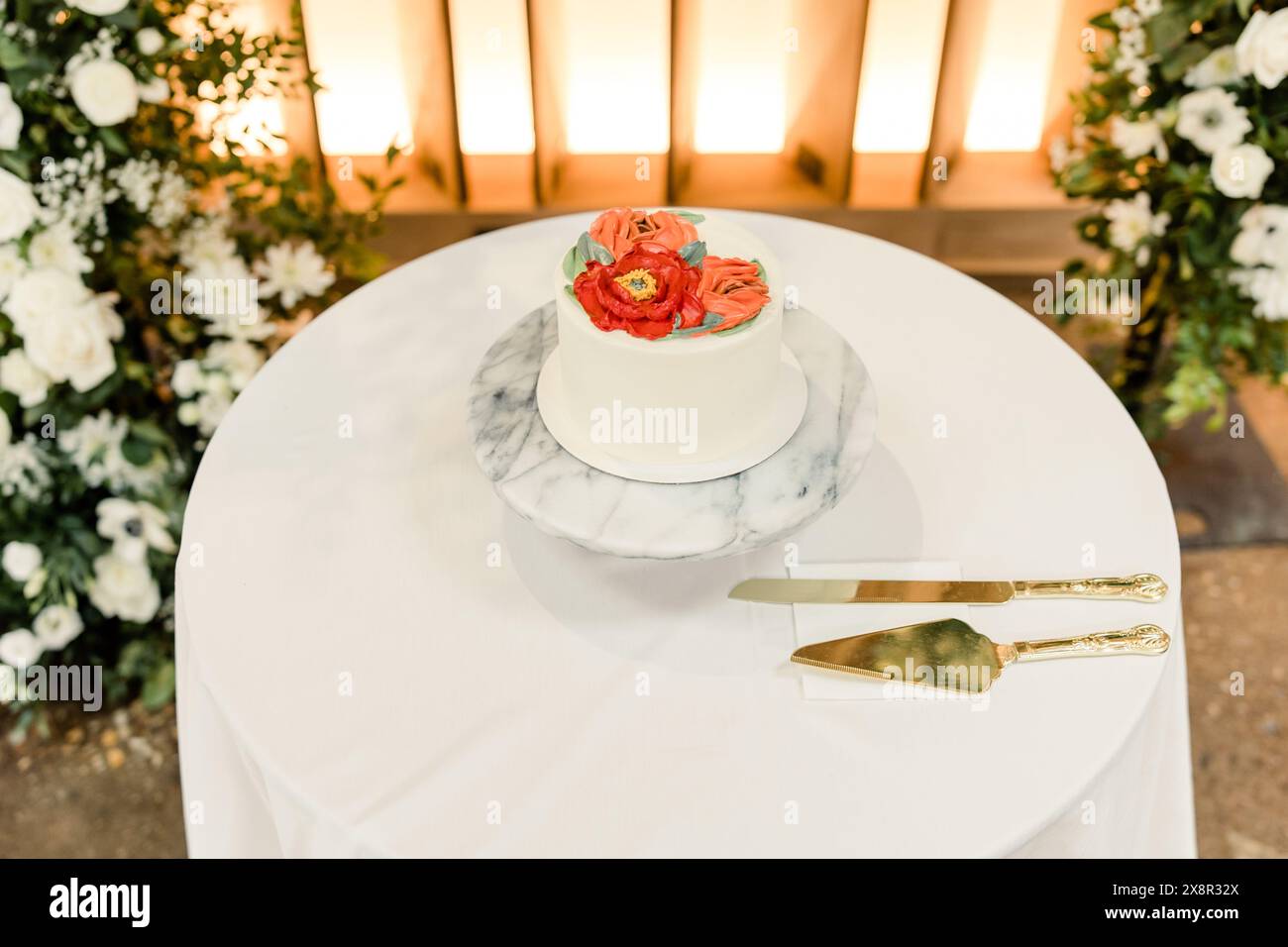 Torta nuziale con design floreale su piedistallo in marmo Foto Stock
